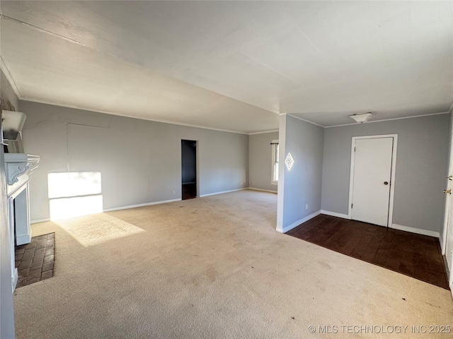 spare room featuring carpet, baseboards, and ornamental molding