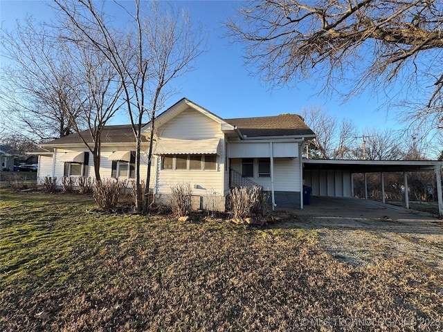 view of side of property featuring a carport, a yard, and driveway