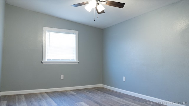 empty room featuring a ceiling fan, baseboards, and wood finished floors