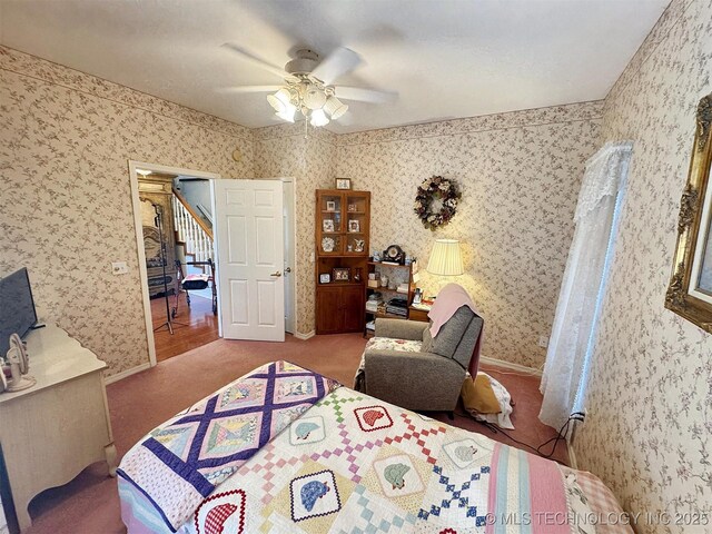 carpeted bedroom with wallpapered walls, baseboards, and ceiling fan