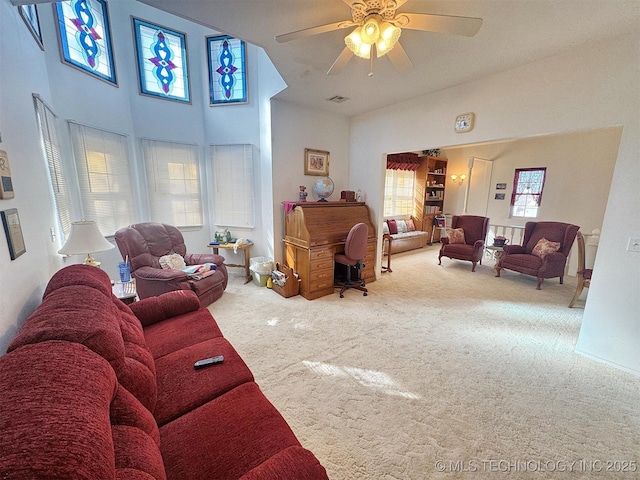 carpeted living area featuring a ceiling fan, visible vents, and high vaulted ceiling