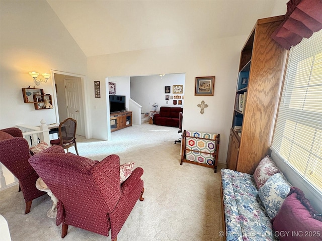 living area featuring light colored carpet and high vaulted ceiling