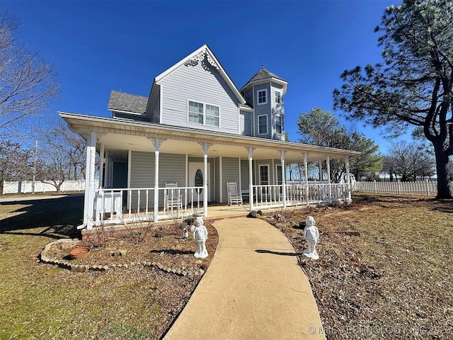 view of front facade featuring covered porch and fence