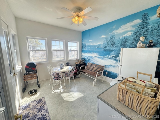 interior space with baseboards and ceiling fan