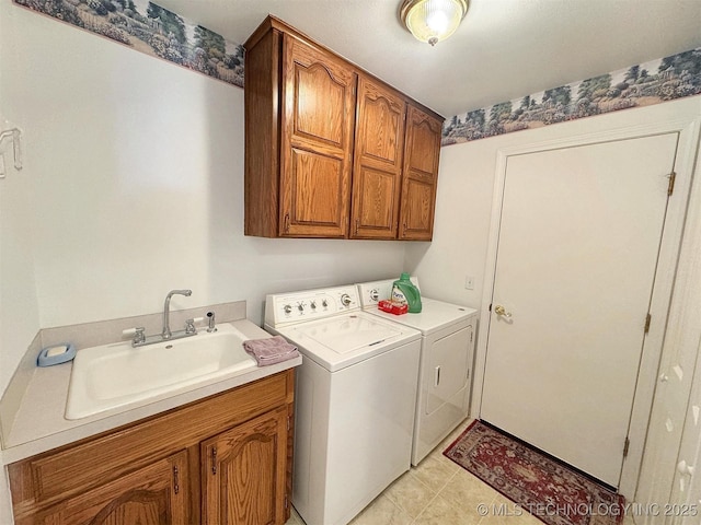 laundry area with a sink, cabinet space, light tile patterned floors, and washing machine and clothes dryer