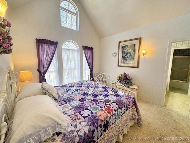 carpeted bedroom with high vaulted ceiling and baseboards