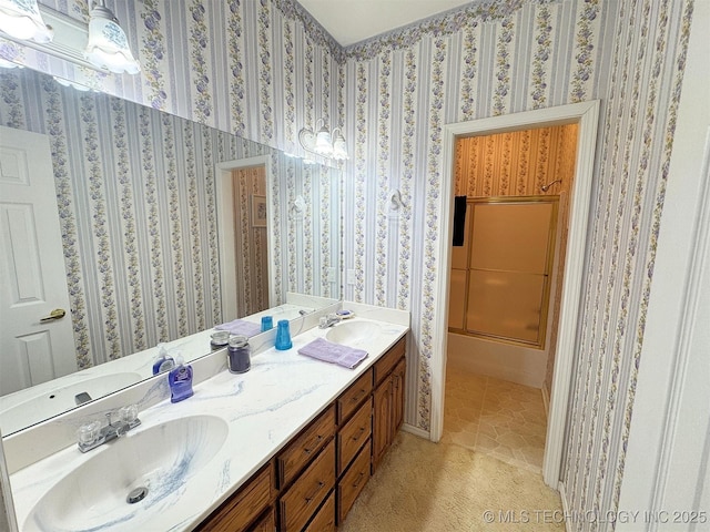 full bathroom with a sink, double vanity, and wallpapered walls