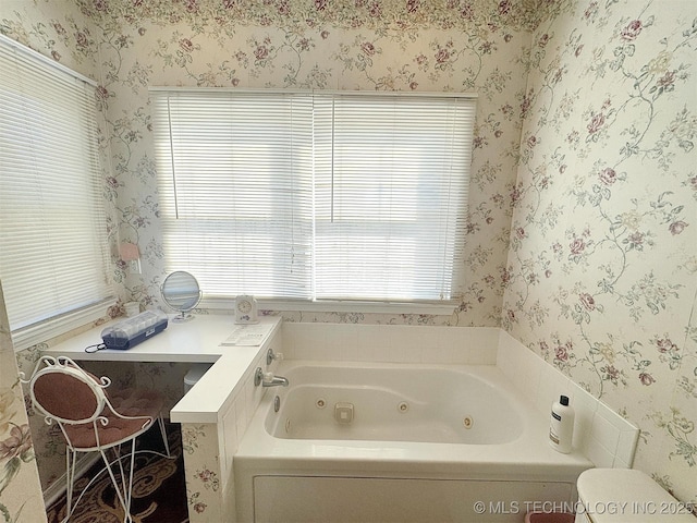 full bath featuring toilet, a jetted tub, and wallpapered walls