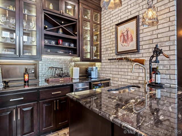 bar with a sink, tasteful backsplash, and hanging light fixtures