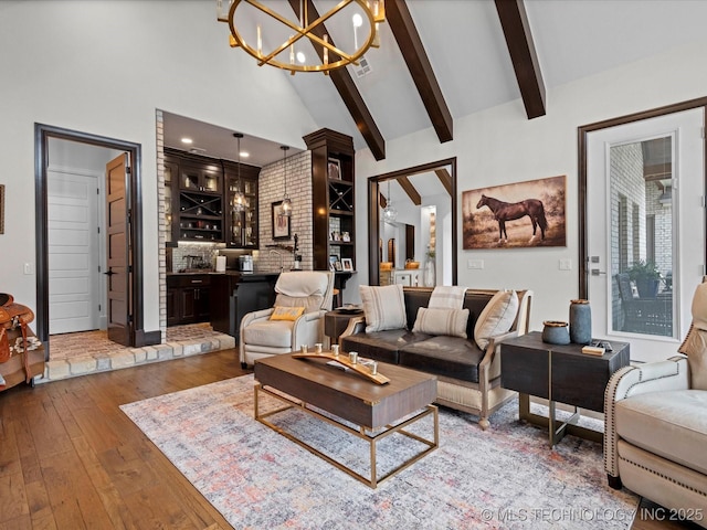 living room featuring visible vents, beamed ceiling, wet bar, a notable chandelier, and wood-type flooring