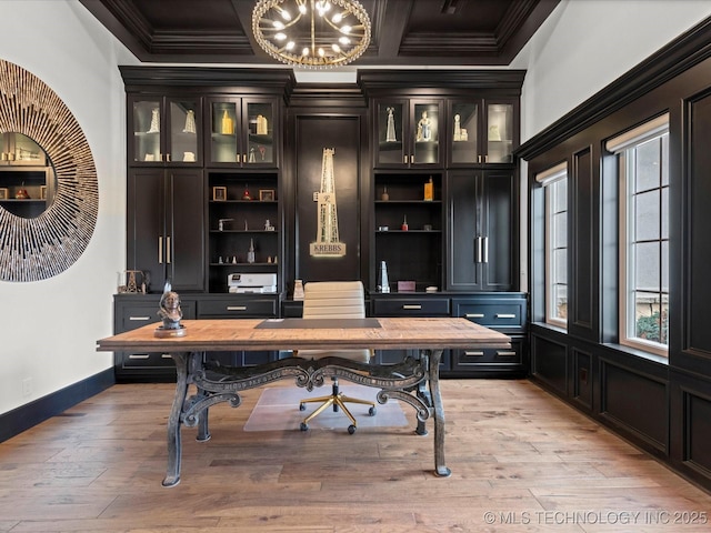 office space featuring built in features, baseboards, light wood-style floors, crown molding, and a notable chandelier