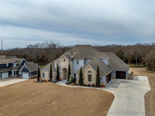 view of front facade featuring a garage, stone siding, concrete driveway, and a front lawn