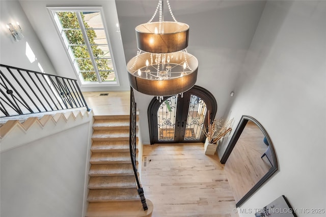 foyer with visible vents, french doors, stairs, and wood finished floors