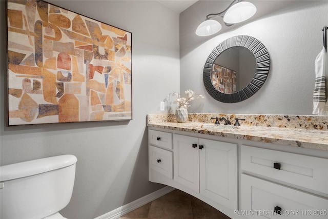 bathroom featuring tile patterned flooring, toilet, vanity, and baseboards