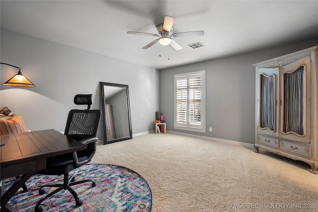 carpeted office space featuring visible vents, a ceiling fan, and baseboards