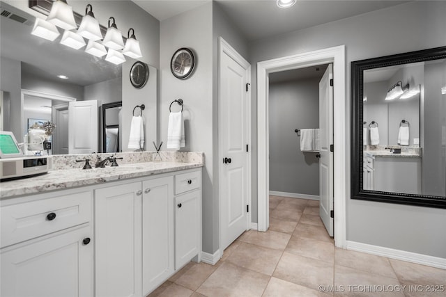 full bath with tile patterned flooring, visible vents, vanity, and baseboards