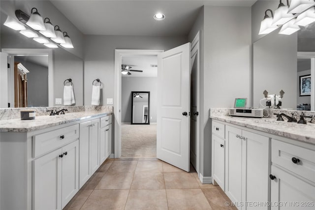 bathroom with tile patterned floors, two vanities, a ceiling fan, and a sink