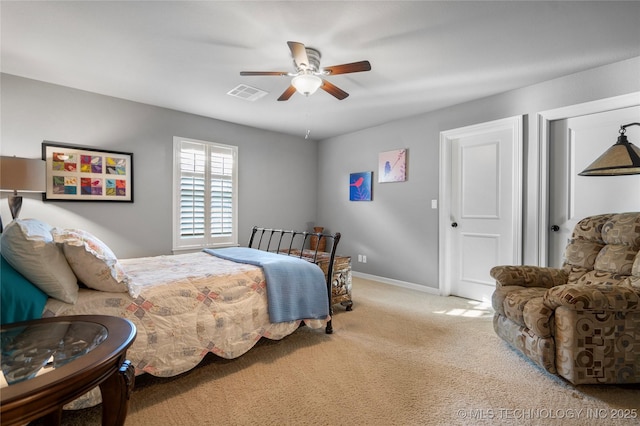 carpeted bedroom with visible vents, a ceiling fan, and baseboards