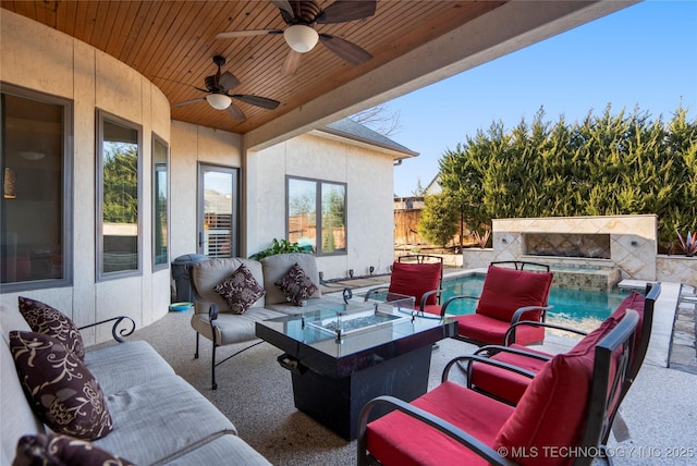 view of patio featuring a fenced in pool, an in ground hot tub, an outdoor living space with a fire pit, and a ceiling fan