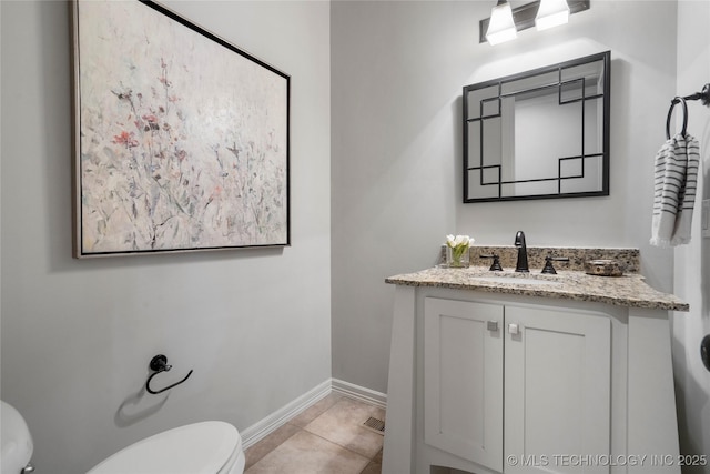 half bath featuring tile patterned floors, baseboards, toilet, and vanity