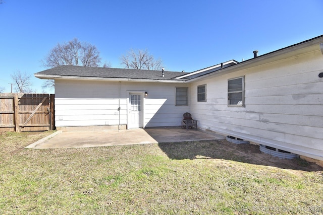 back of house featuring a lawn, a patio, and fence