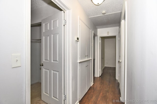 hall featuring dark wood-style flooring and a textured ceiling