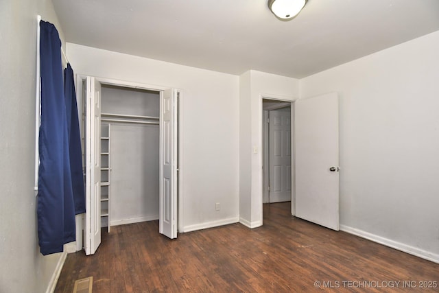 unfurnished bedroom featuring wood finished floors, visible vents, and baseboards