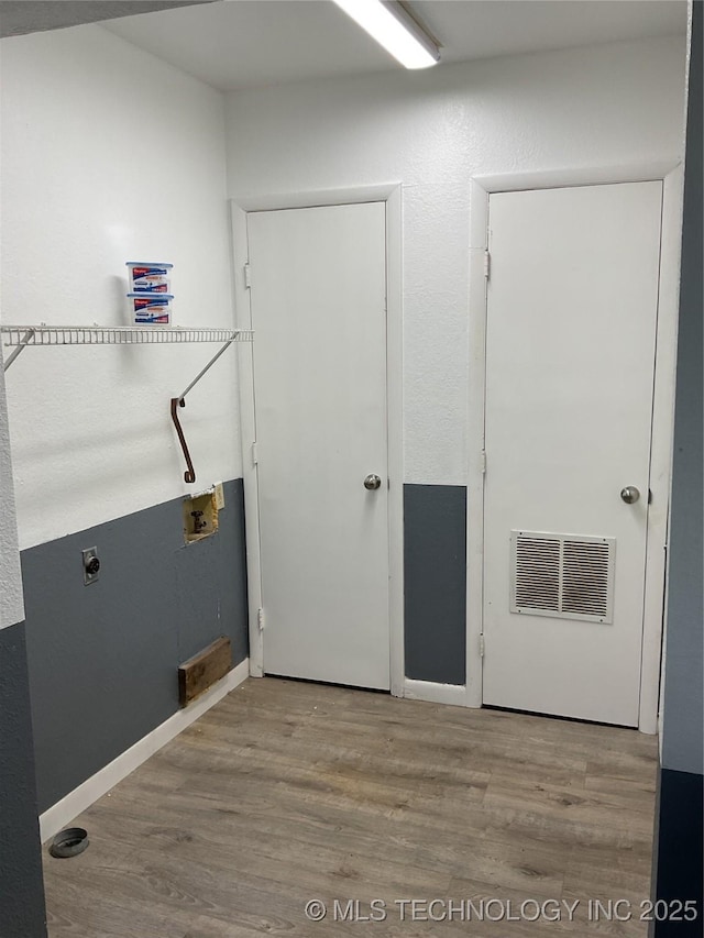 laundry room featuring hookup for a washing machine, wood finished floors, visible vents, baseboards, and laundry area