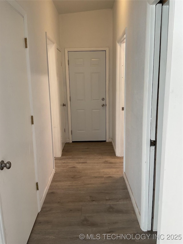 hallway with baseboards and wood finished floors