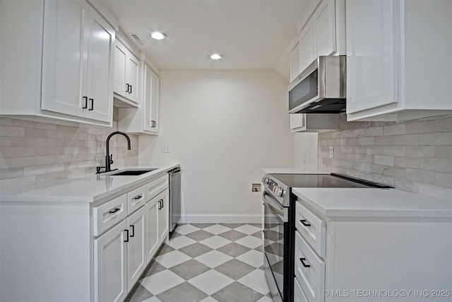 kitchen with baseboards, light floors, light countertops, stainless steel appliances, and a sink