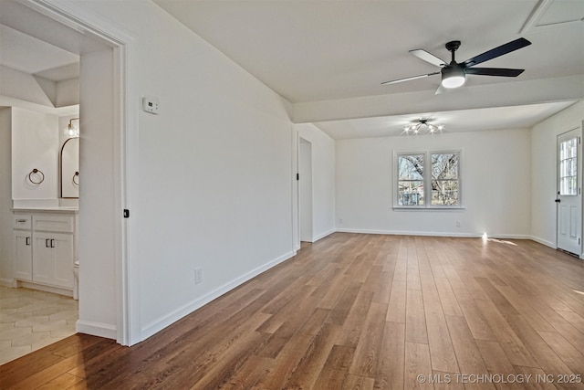 spare room with baseboards, wood finished floors, and a ceiling fan