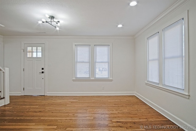 foyer entrance with recessed lighting, light wood-type flooring, crown molding, and baseboards