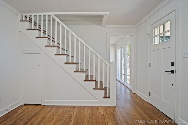 entryway with stairs, wood finished floors, and crown molding