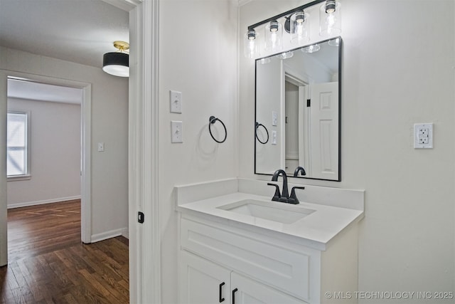 bathroom featuring baseboards, wood finished floors, and vanity