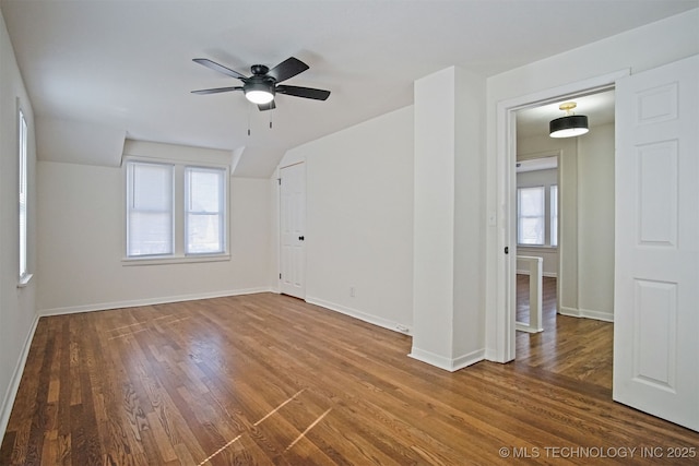 empty room featuring wood finished floors, baseboards, and ceiling fan