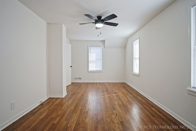 unfurnished room with visible vents, baseboards, a ceiling fan, and dark wood-style flooring