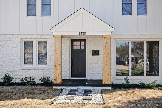 entrance to property featuring stone siding and board and batten siding