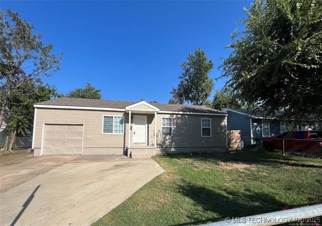 single story home featuring a front yard, a garage, and driveway