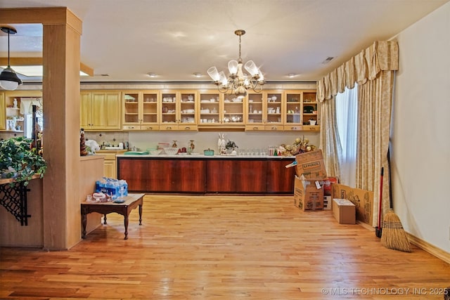 bar featuring an inviting chandelier, decorative light fixtures, visible vents, and light wood finished floors