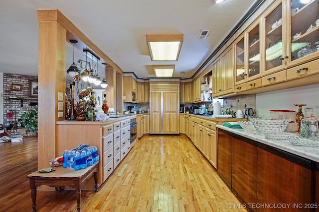 kitchen featuring paneled fridge, visible vents, light wood finished floors, oven, and glass insert cabinets