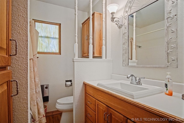 bathroom featuring a shower with curtain, toilet, and vanity