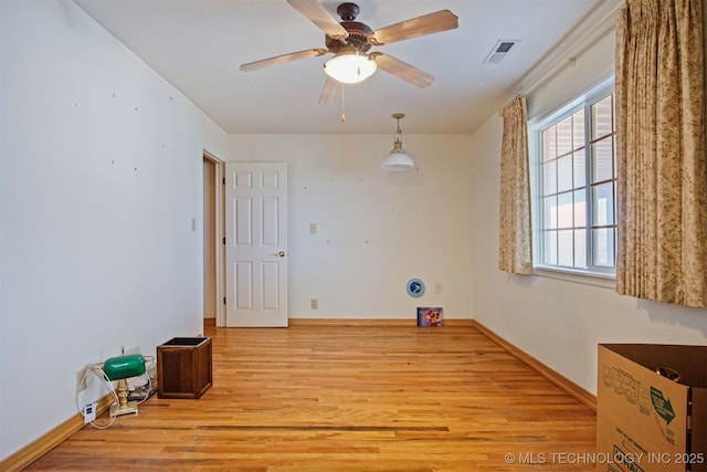 empty room featuring visible vents, baseboards, light wood-style floors, and a ceiling fan