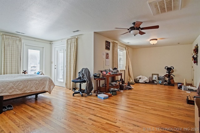 bedroom with visible vents, light wood-type flooring, and access to outside