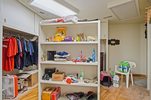 interior space featuring visible vents, attic access, and wood finished floors