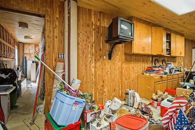 kitchen featuring brown cabinets, wooden walls, concrete flooring, and wooden ceiling