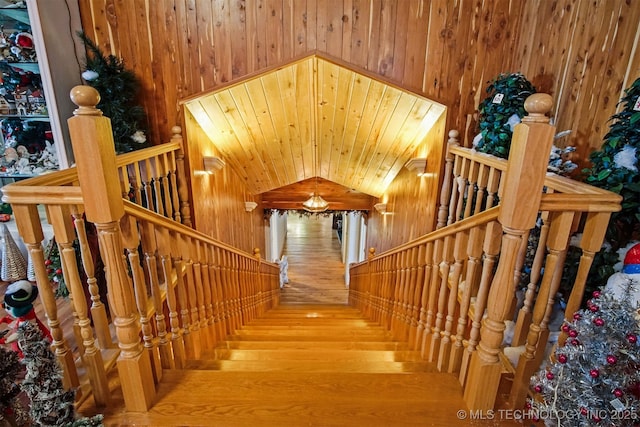 stairway with wooden ceiling and wood walls