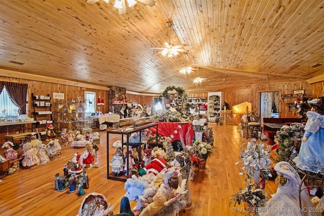 misc room with a ceiling fan, hardwood / wood-style flooring, wood walls, lofted ceiling, and wood ceiling