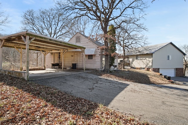 exterior space featuring aphalt driveway, a carport, and an attached garage