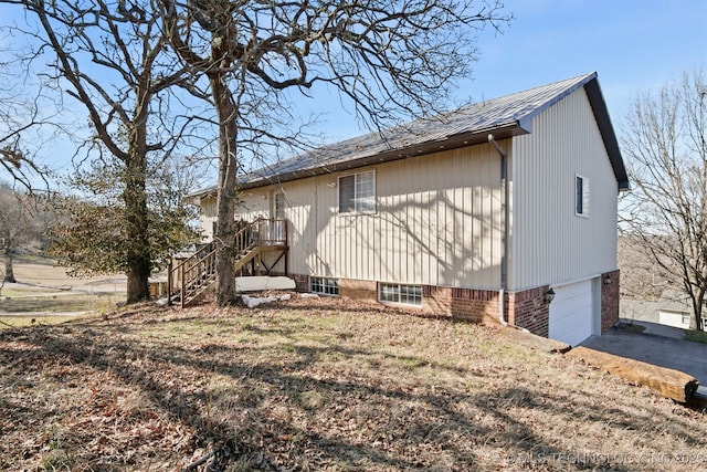 view of side of property featuring stairs, concrete driveway, and a garage