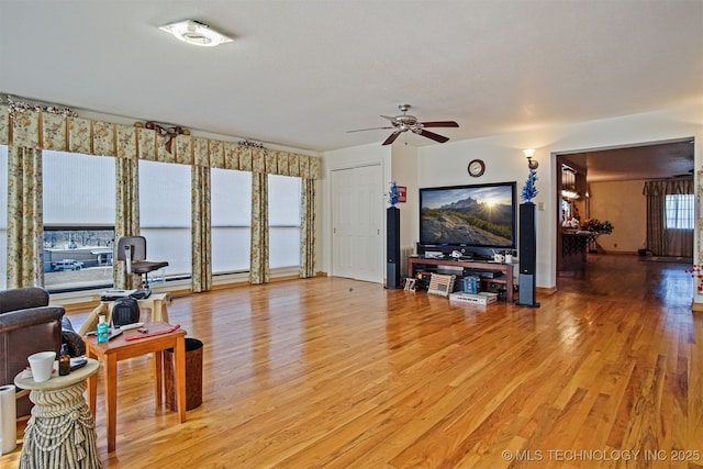 living room featuring a ceiling fan and light wood-type flooring